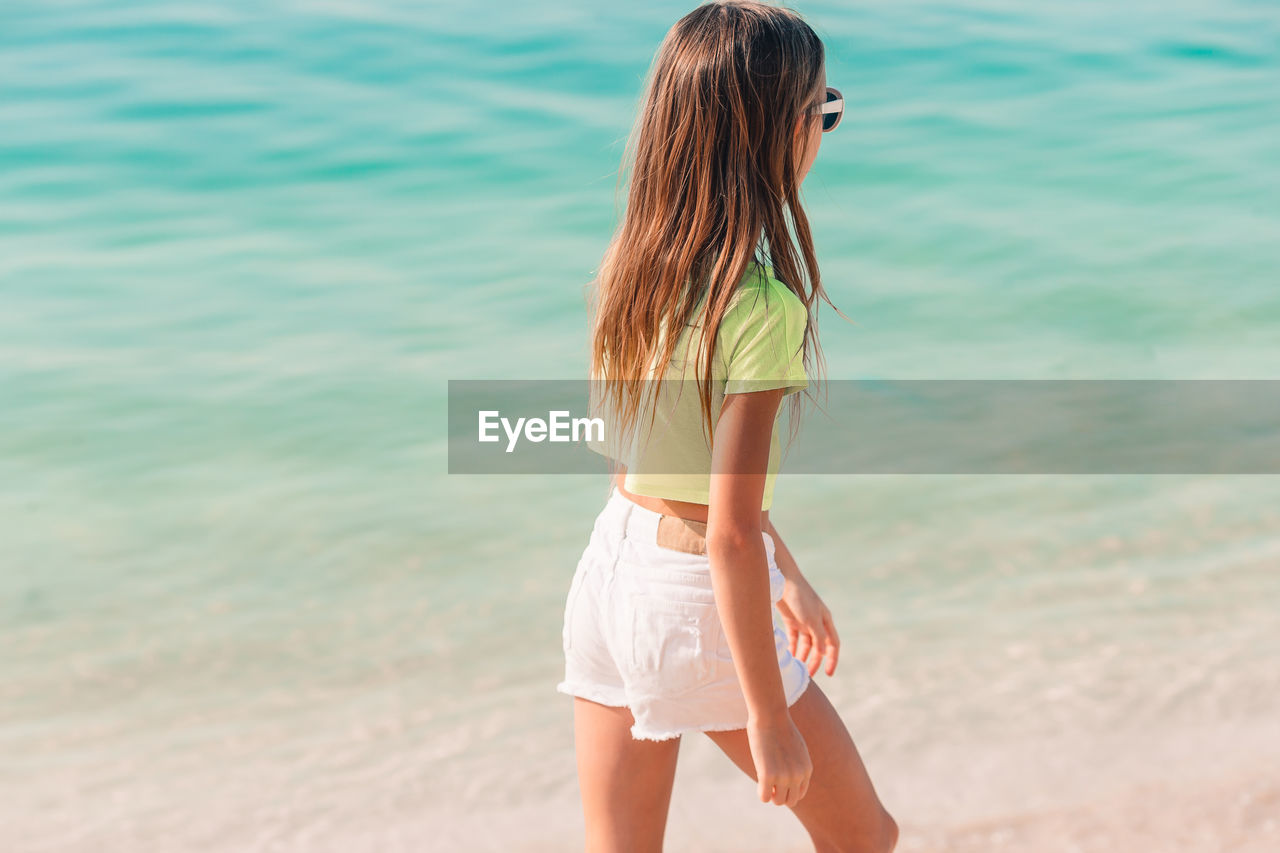 Rear view of girl walking on beach