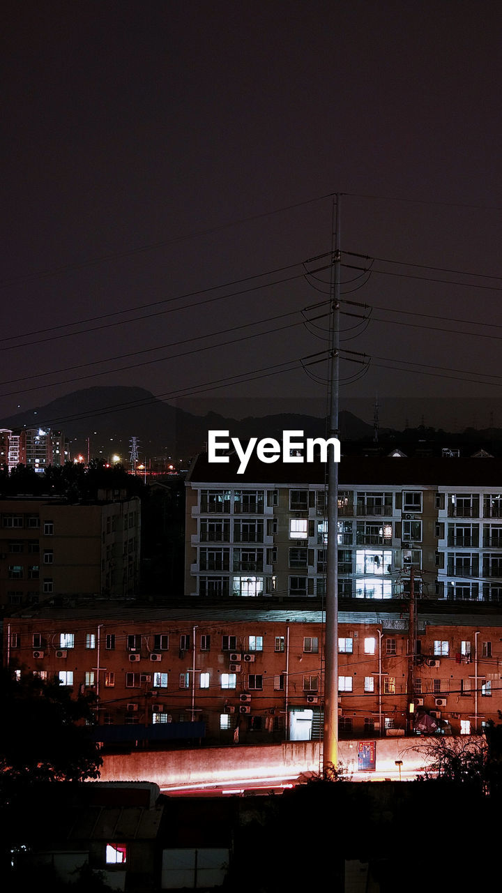 ILLUMINATED BUILDINGS IN CITY AT NIGHT