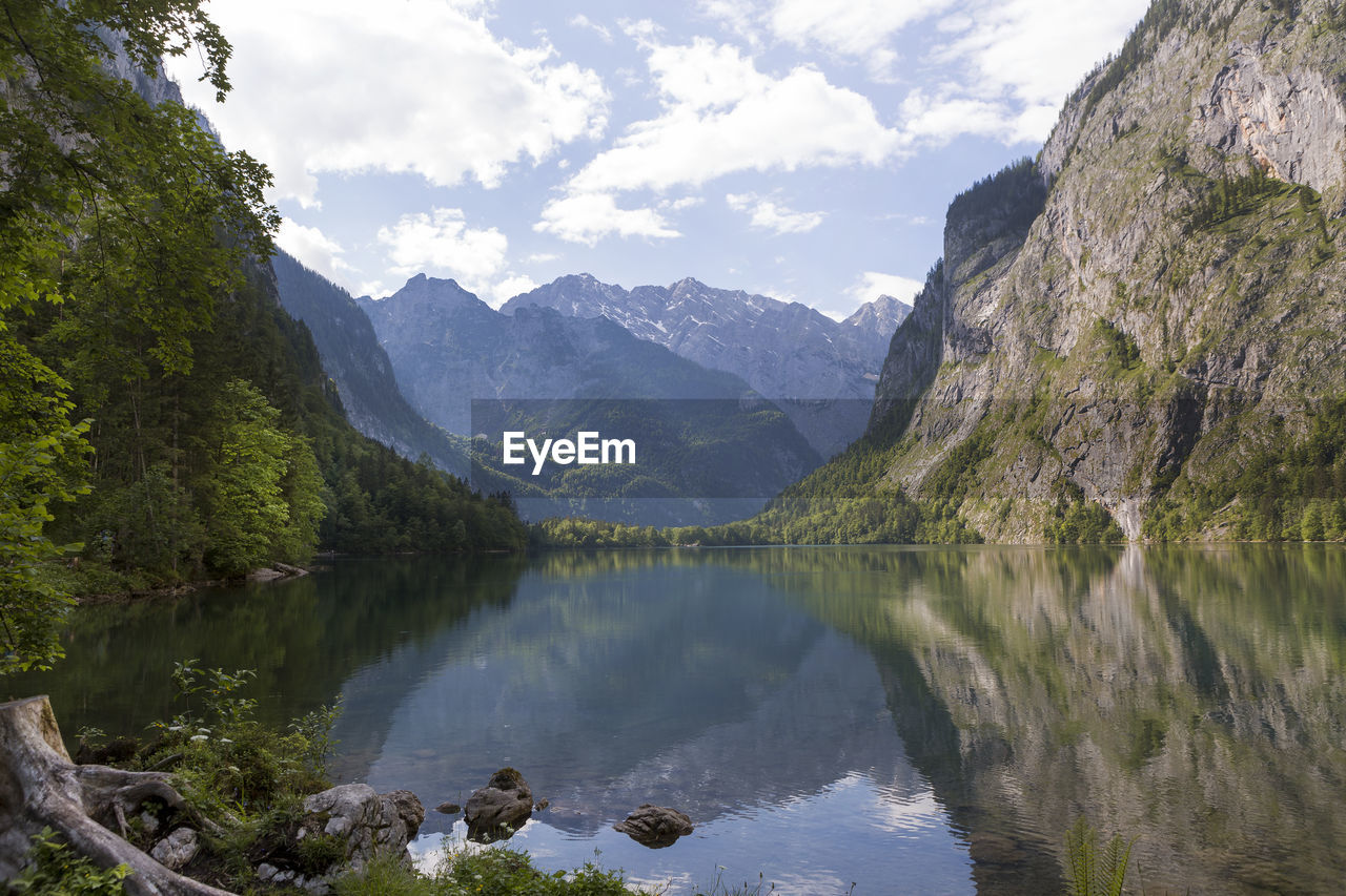 scenic view of lake and mountains against cloudy sky