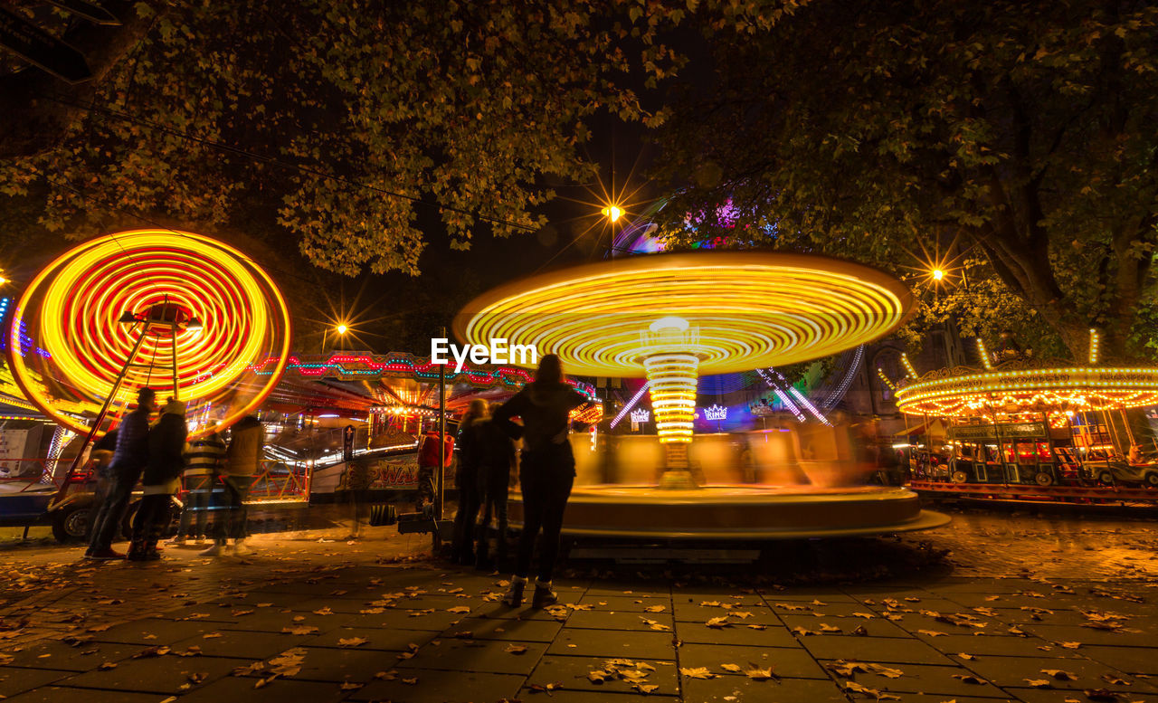 ILLUMINATED CAROUSEL AT AMUSEMENT PARK