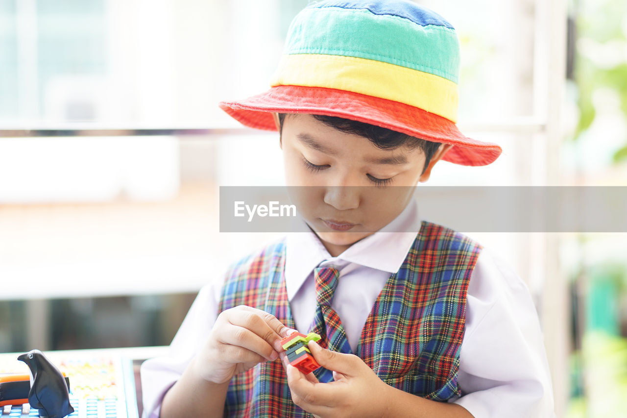 LOW ANGLE VIEW OF GIRL LOOKING AWAY WHILE HOLDING CAMERA