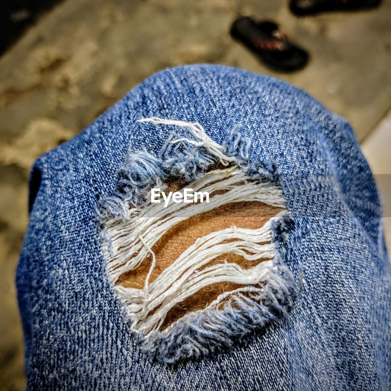 Cropped image of person wearing torn jeans