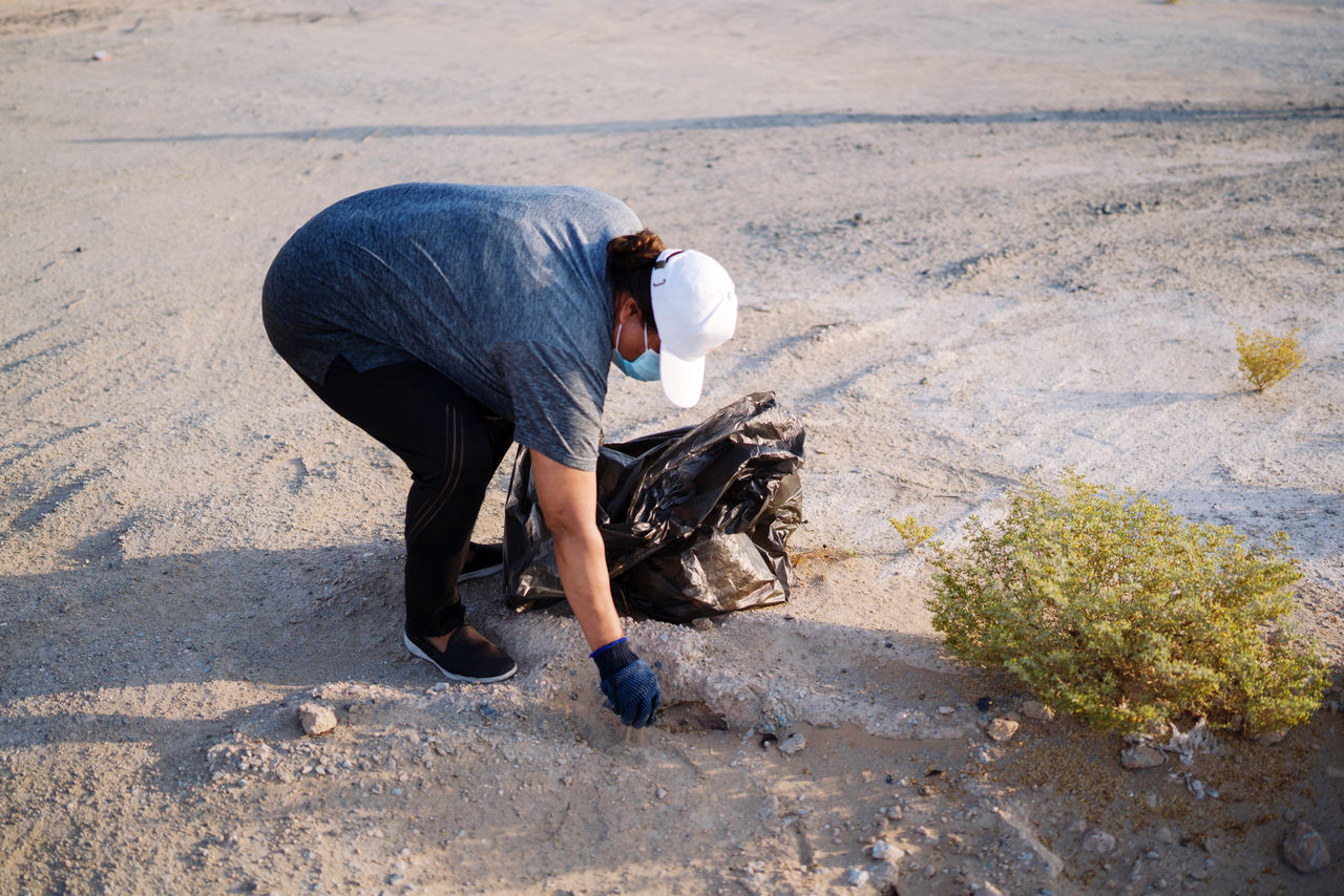 Woman collecting garbage outdoors