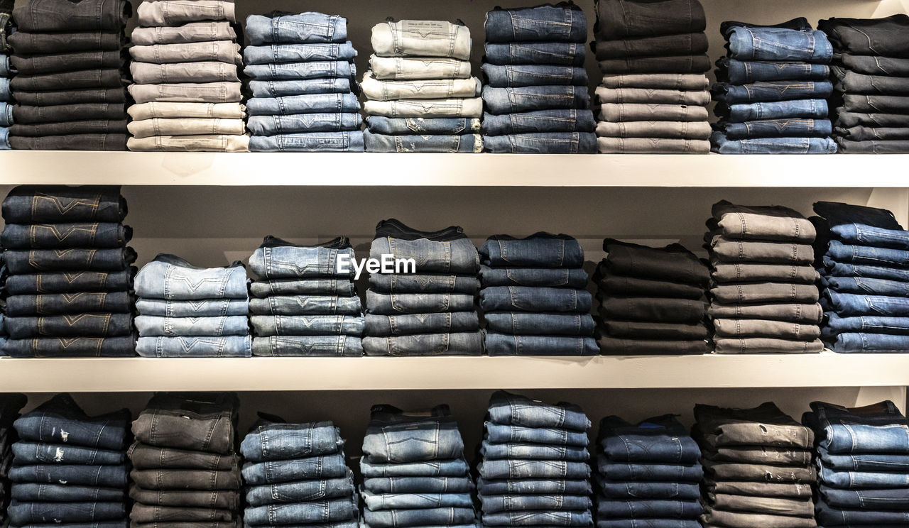 Stack of folded jeans on store shelves