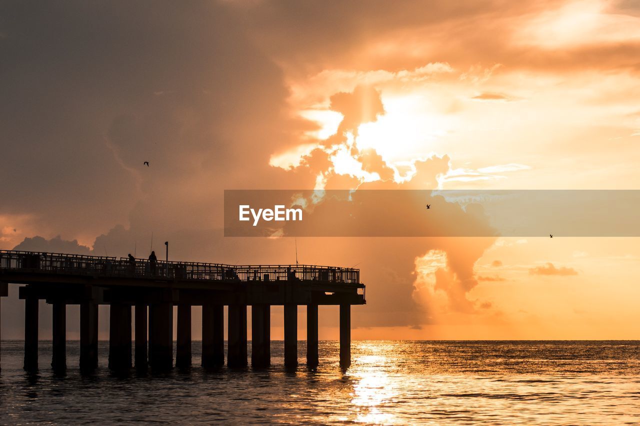 SILHOUETTE PIER ON SEA AGAINST ORANGE SKY