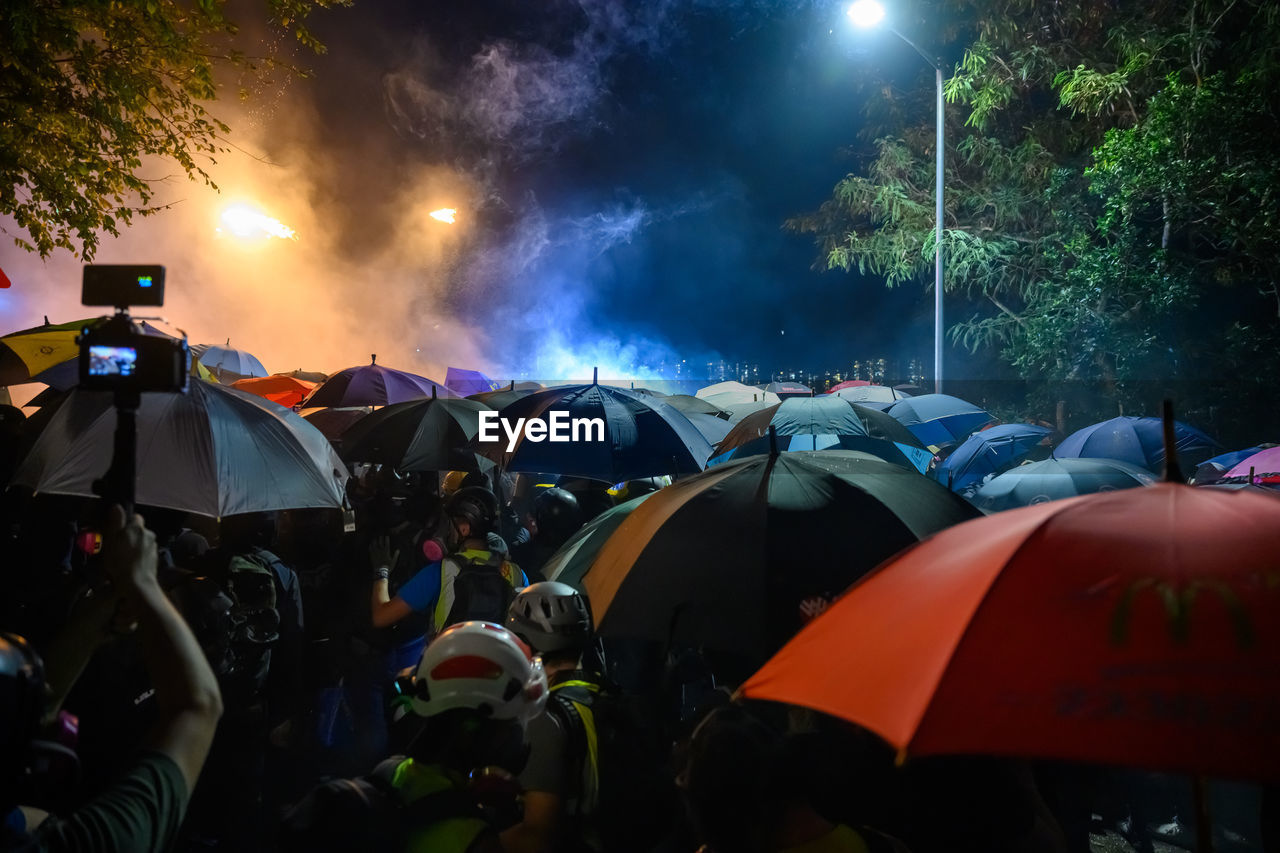 PEOPLE ON WET STREET DURING NIGHT