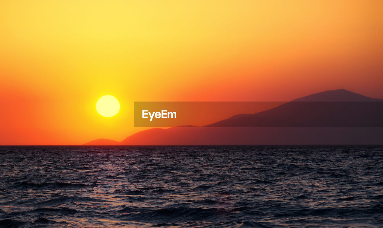 SCENIC VIEW OF SEA AGAINST ORANGE SKY