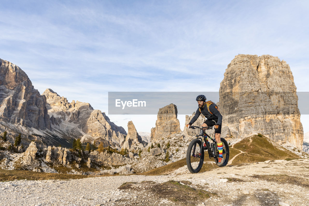 Italy, cortina d'ampezzo, man cycling with mountain bike in the dolomites mountains