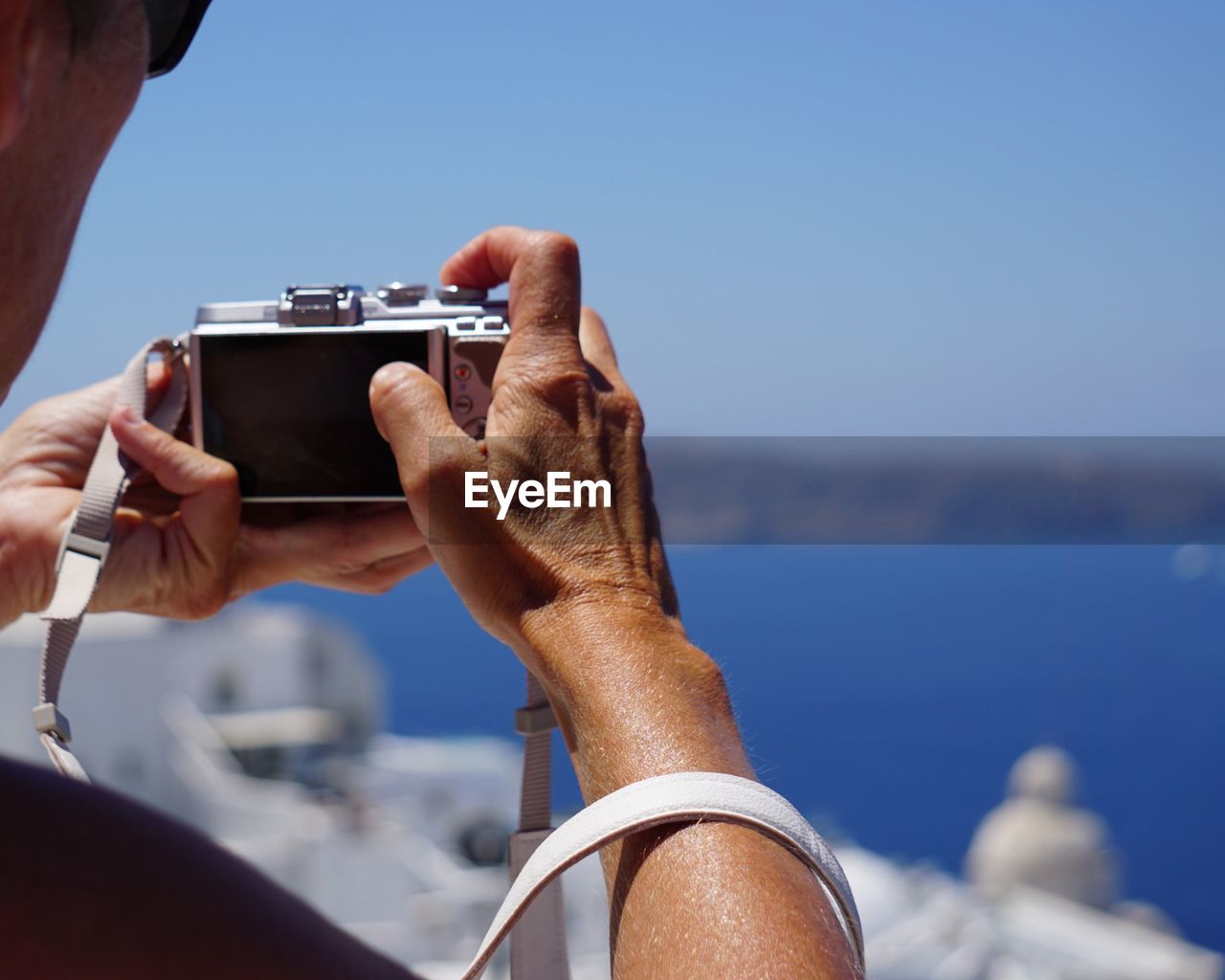 Man photographing sea against sky