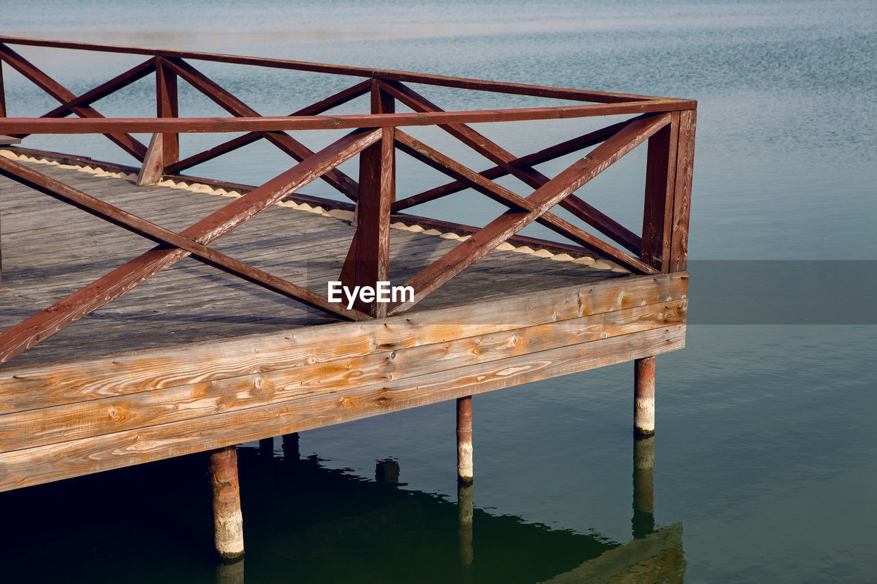 Part of the wooden fence of the pier on the lake on an autumn morning