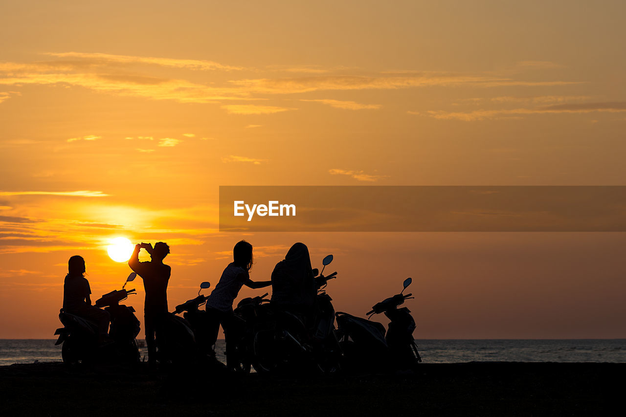 Silhouette people at beach during sunset