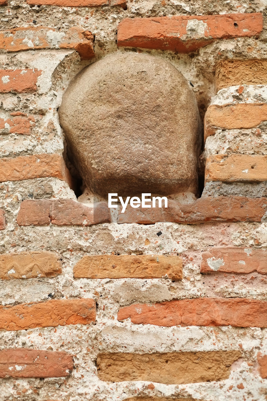 LOW ANGLE VIEW OF WEATHERED BRICK WALL