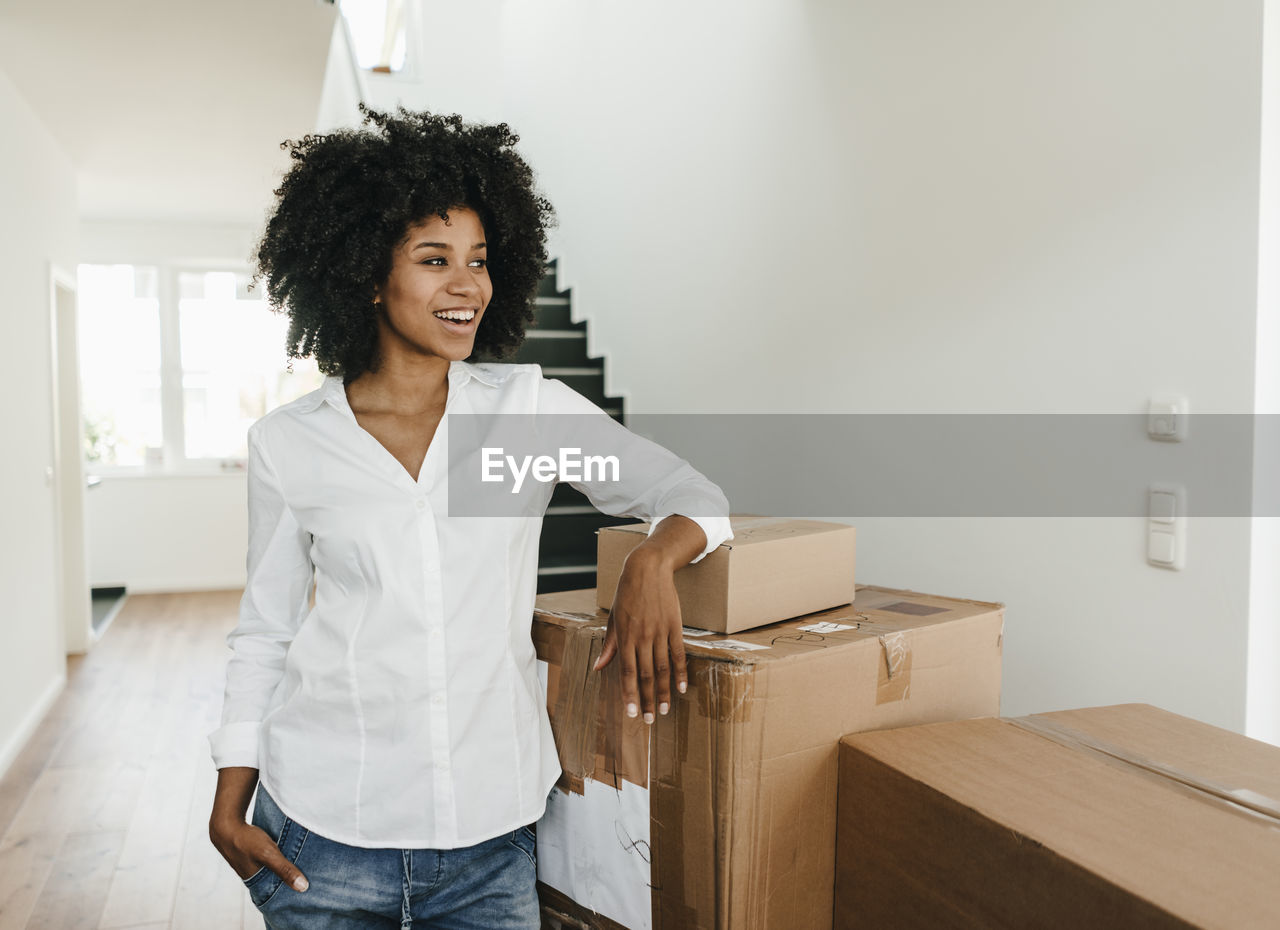 Smiling young woman with cardboard boxes