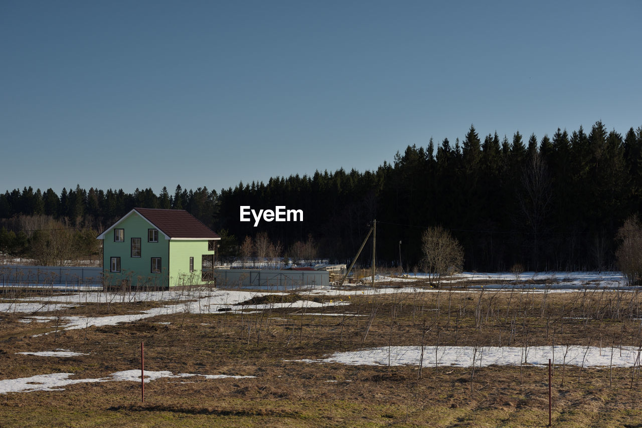 SCENIC VIEW OF TREES AND BUILDINGS AGAINST CLEAR SKY