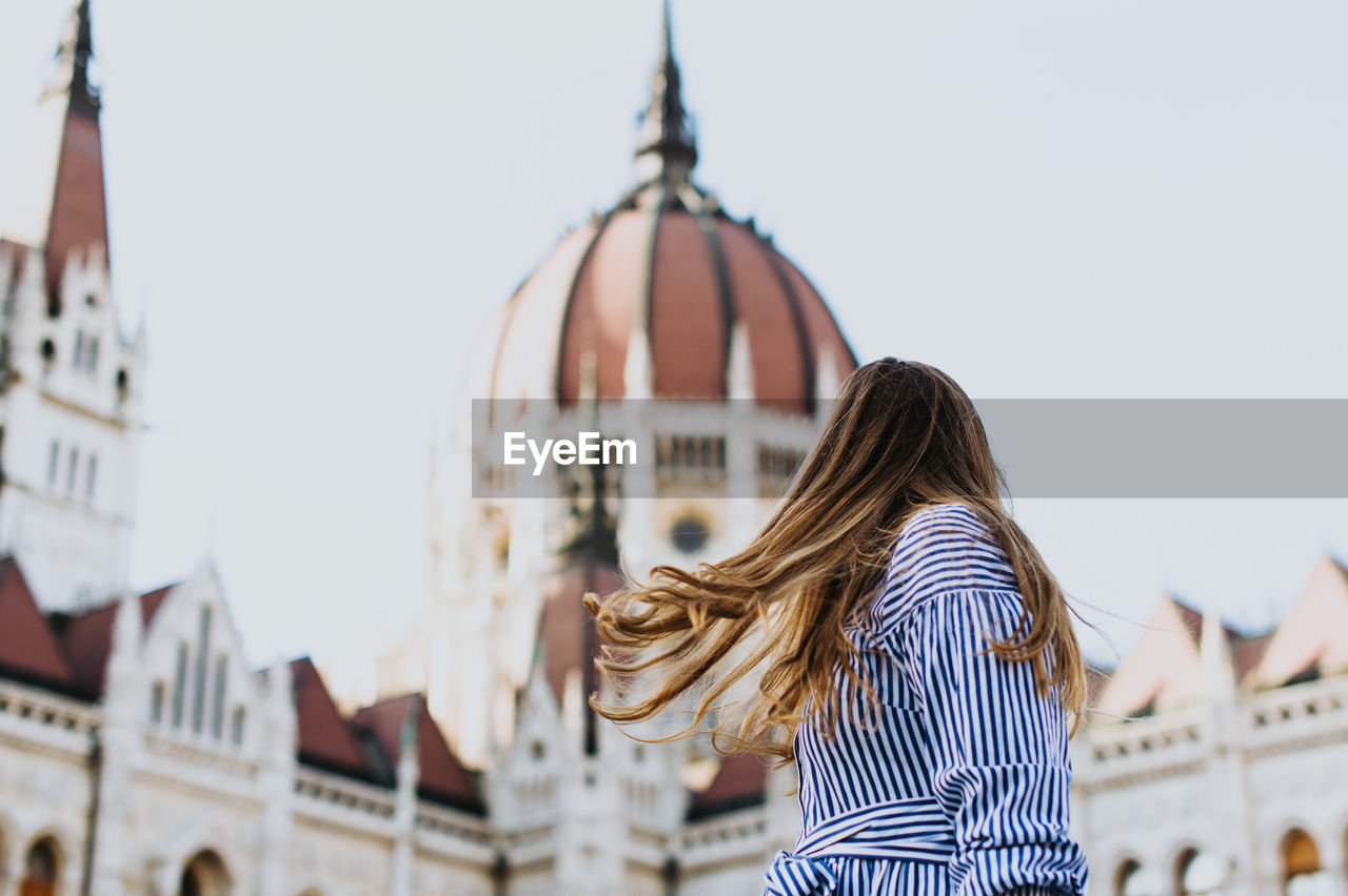 Woman walking against church in city