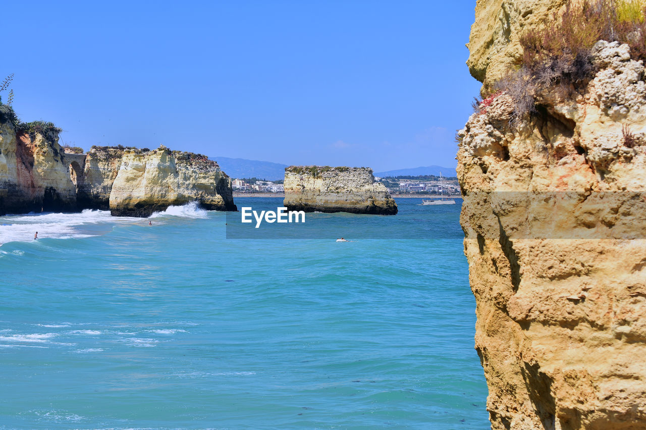 ROCKS IN SEA AGAINST CLEAR SKY
