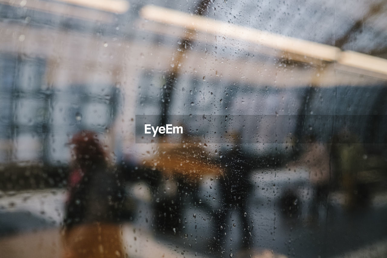 Rain drops blurred motion of man on glass