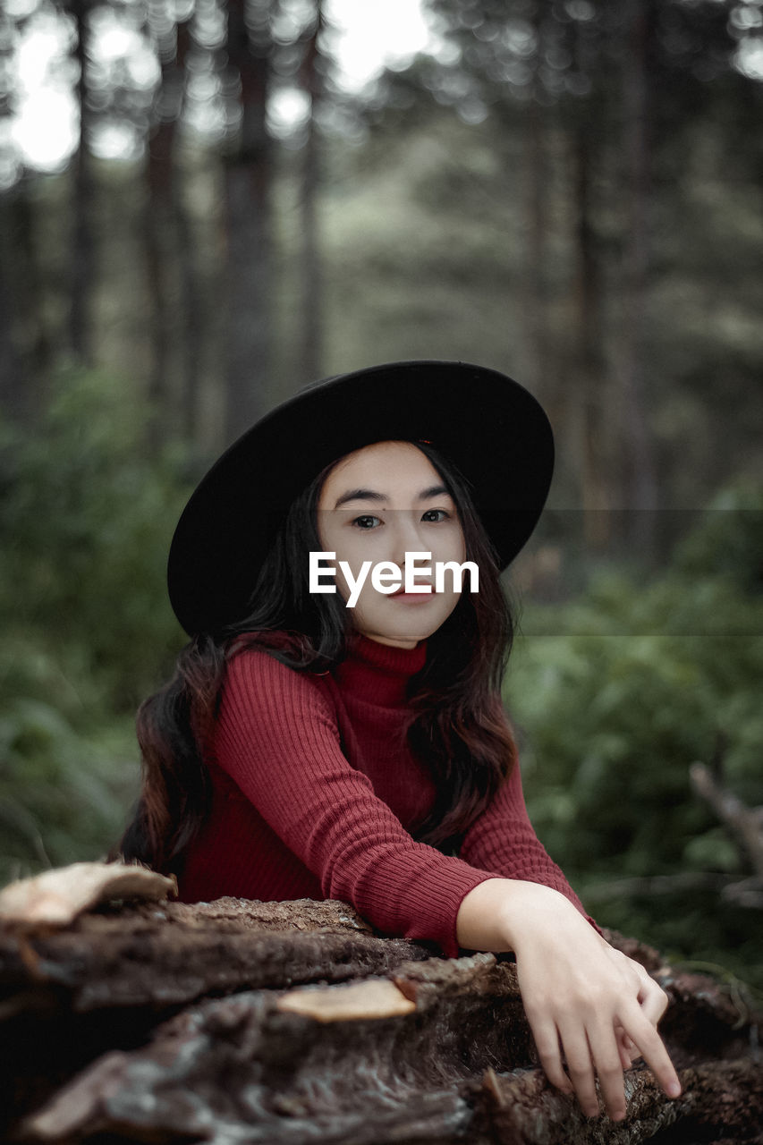 Portrait of woman wearing hat in forest