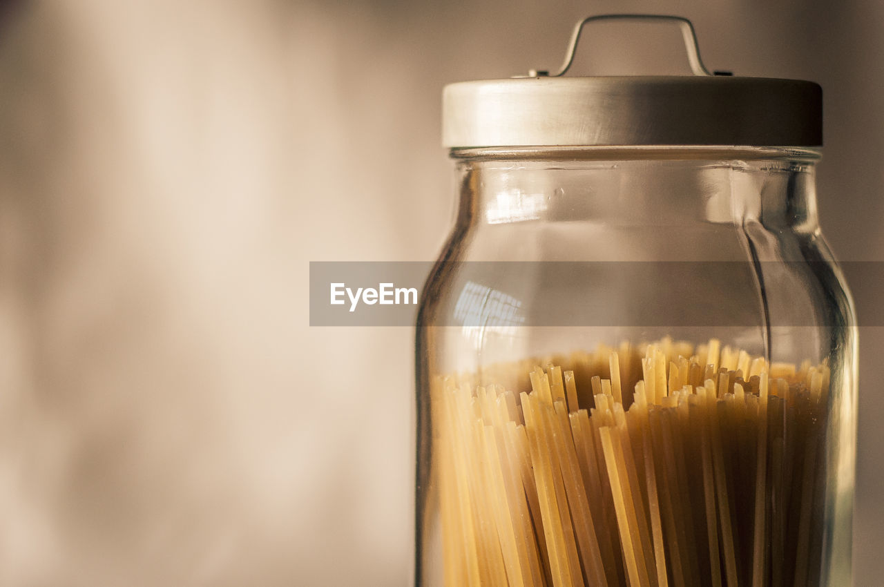 Spaghetti inside a transparent cristal jar with a gray metal cap