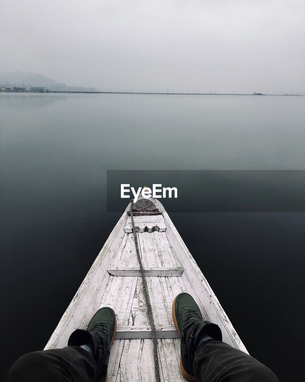 Low section of man sitting in rowboat in lake