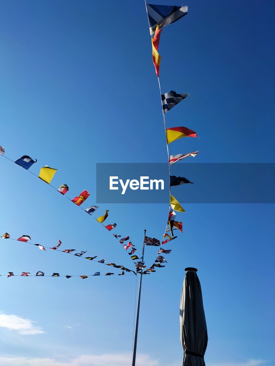 sky, kite sports, nature, flying, kite - toy, toy, windsports, kite, wind, blue, low angle view, celebration, flag, multi colored, sports, tradition, cloud, hanging, day, no people, event, outdoors, environment, in a row, decoration, clear sky, sport kite