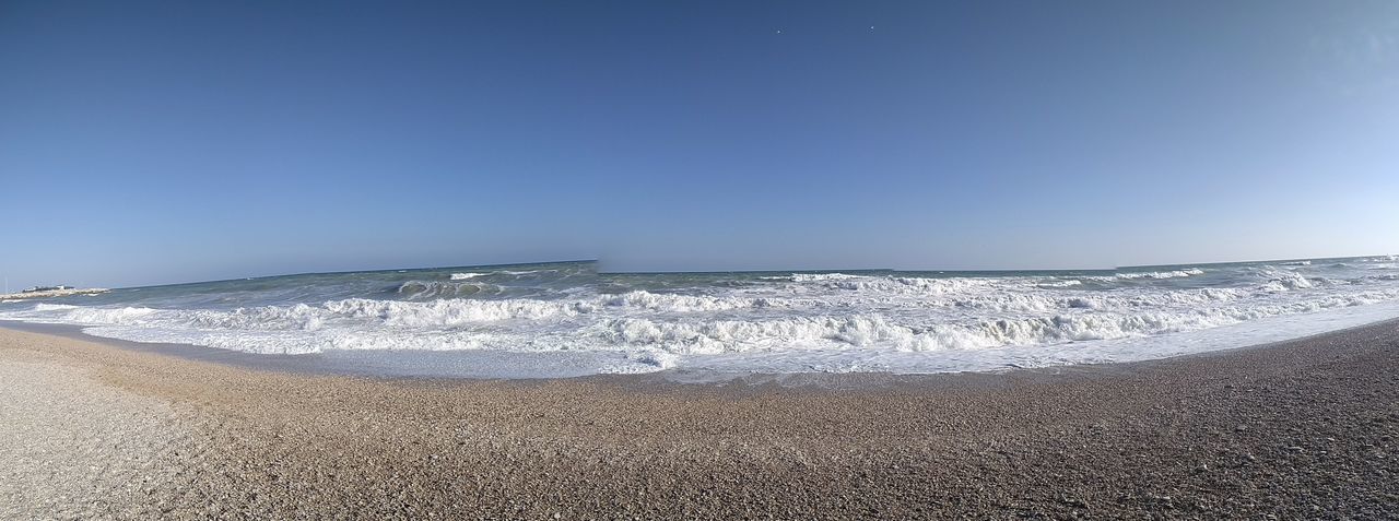 SCENIC VIEW OF SEA WAVES SPLASHING AGAINST CLEAR SKY