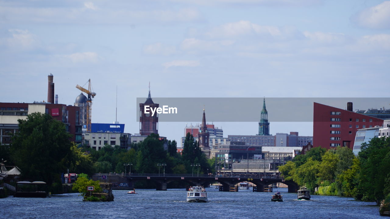 VIEW OF BUILDINGS BY RIVER AGAINST SKY