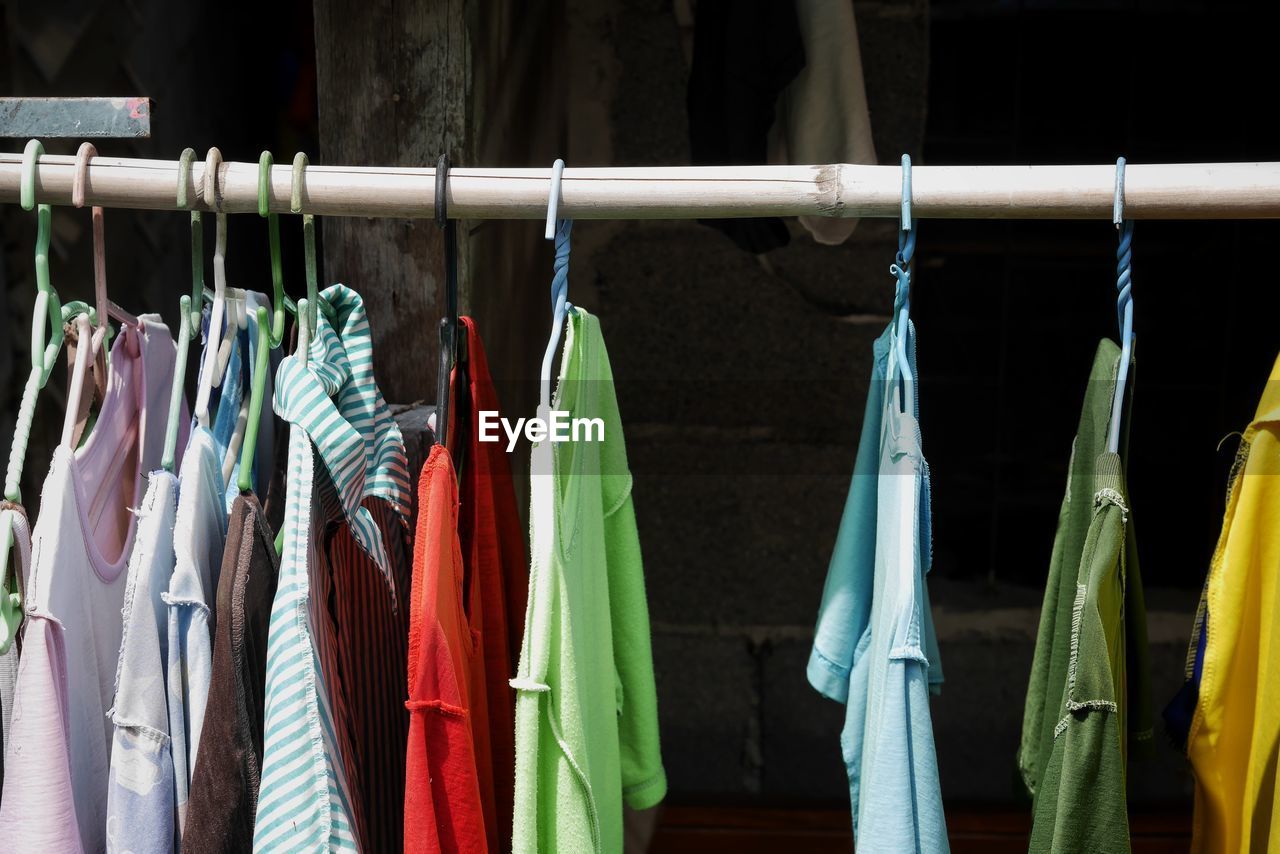 CLOSE-UP OF CLOTHES HANGING ON RACK