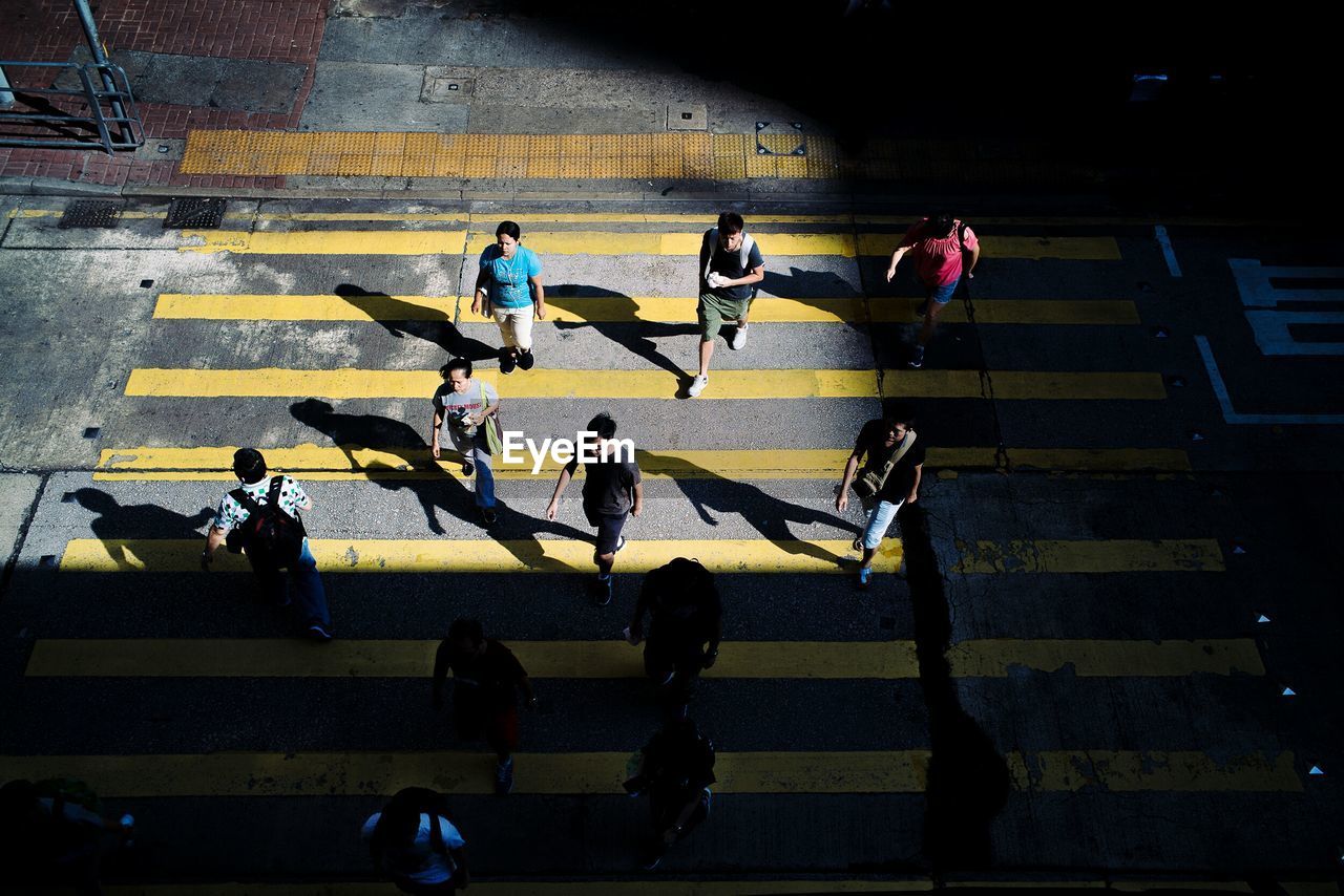 HIGH ANGLE VIEW OF PEOPLE ON ROAD