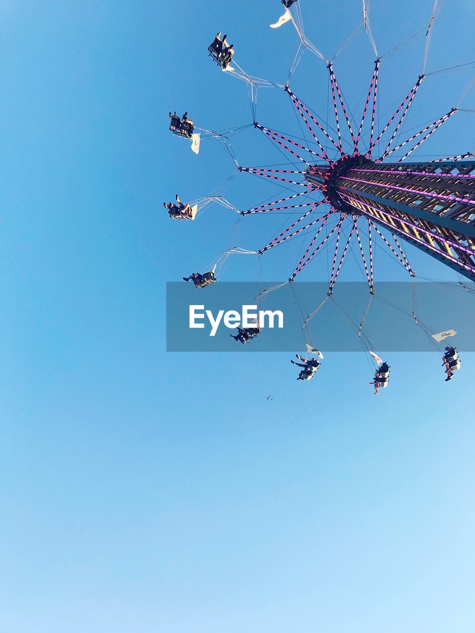 LOW ANGLE VIEW OF AMUSEMENT PARK AGAINST CLEAR BLUE SKY