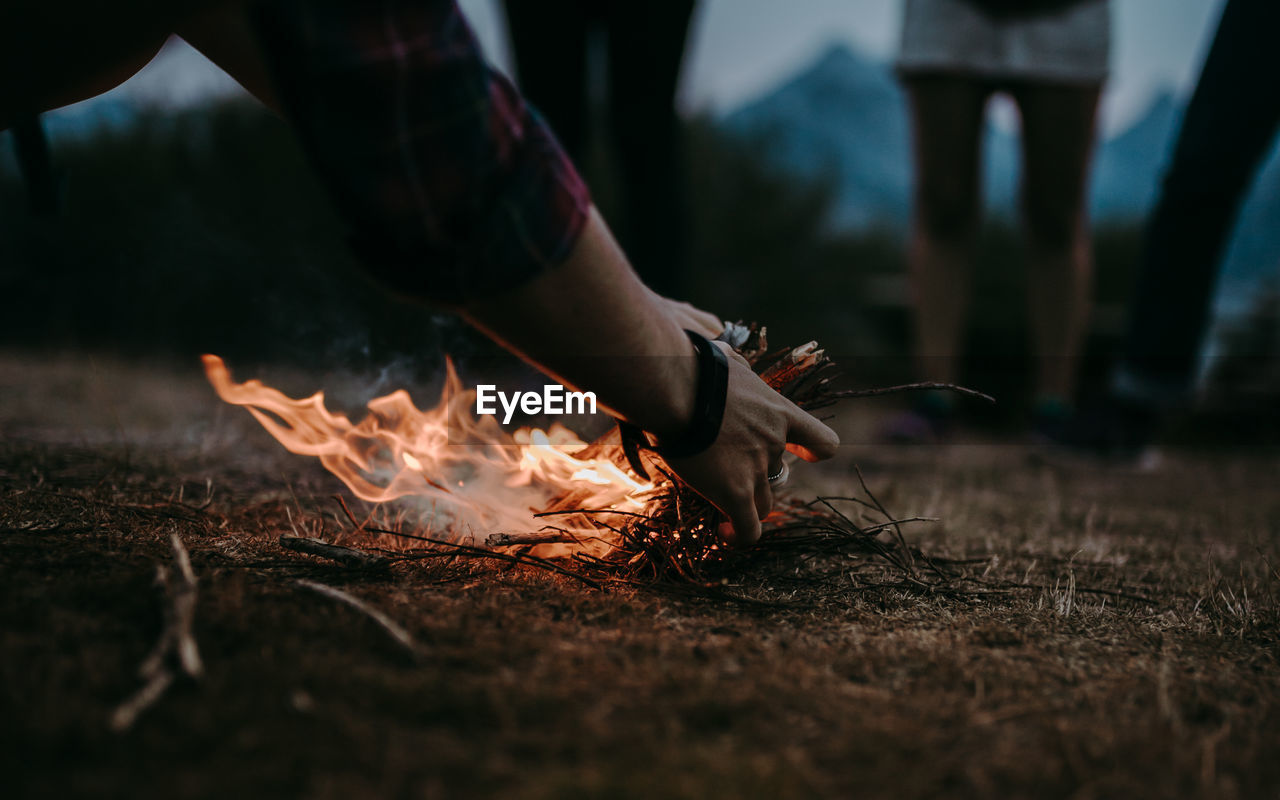 Woman stsrting a bonfire on wooden log