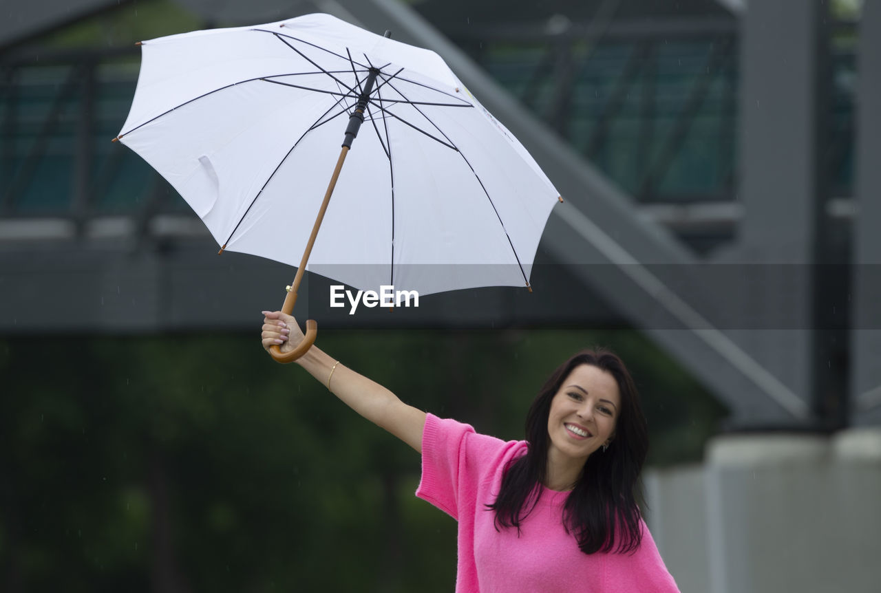 portrait of young woman holding umbrella