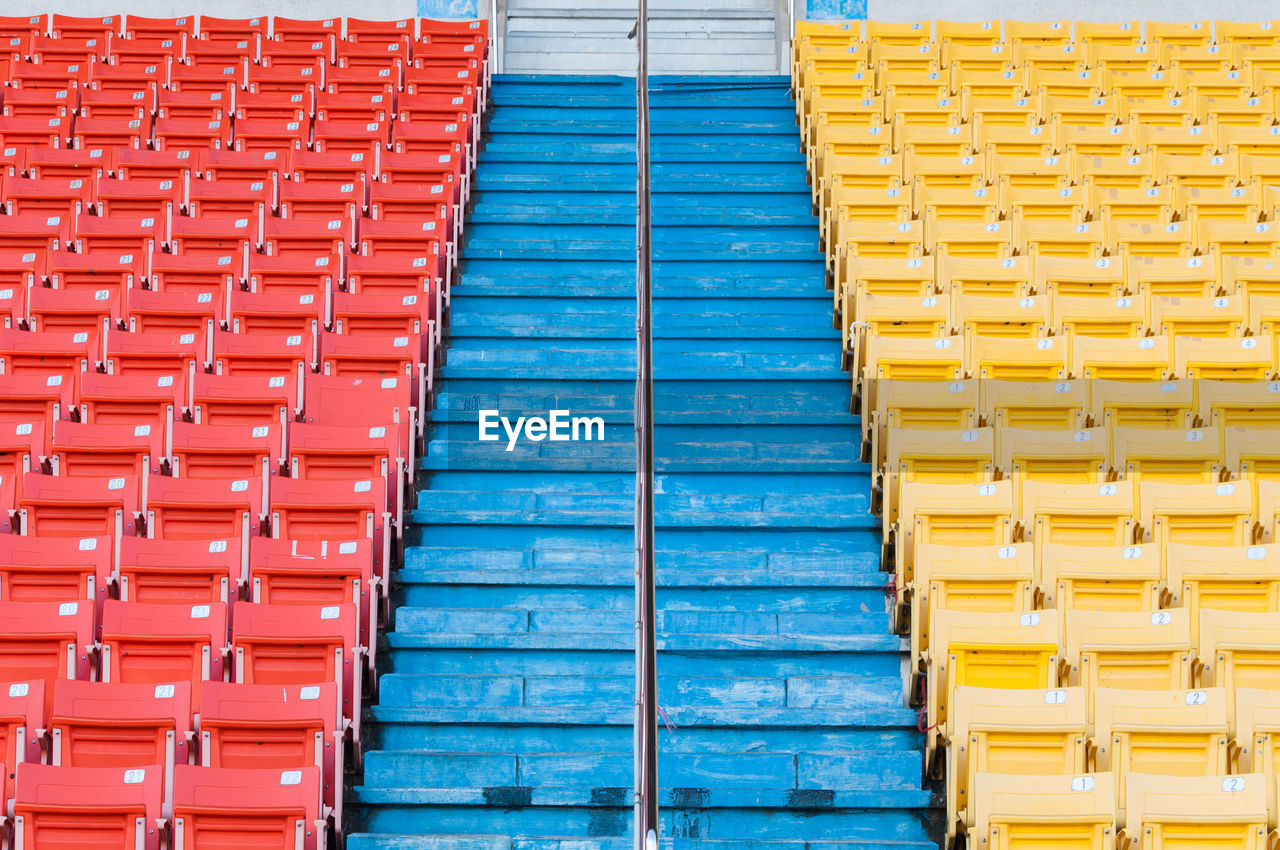 HIGH ANGLE VIEW OF MULTI COLORED EMPTY SEATS