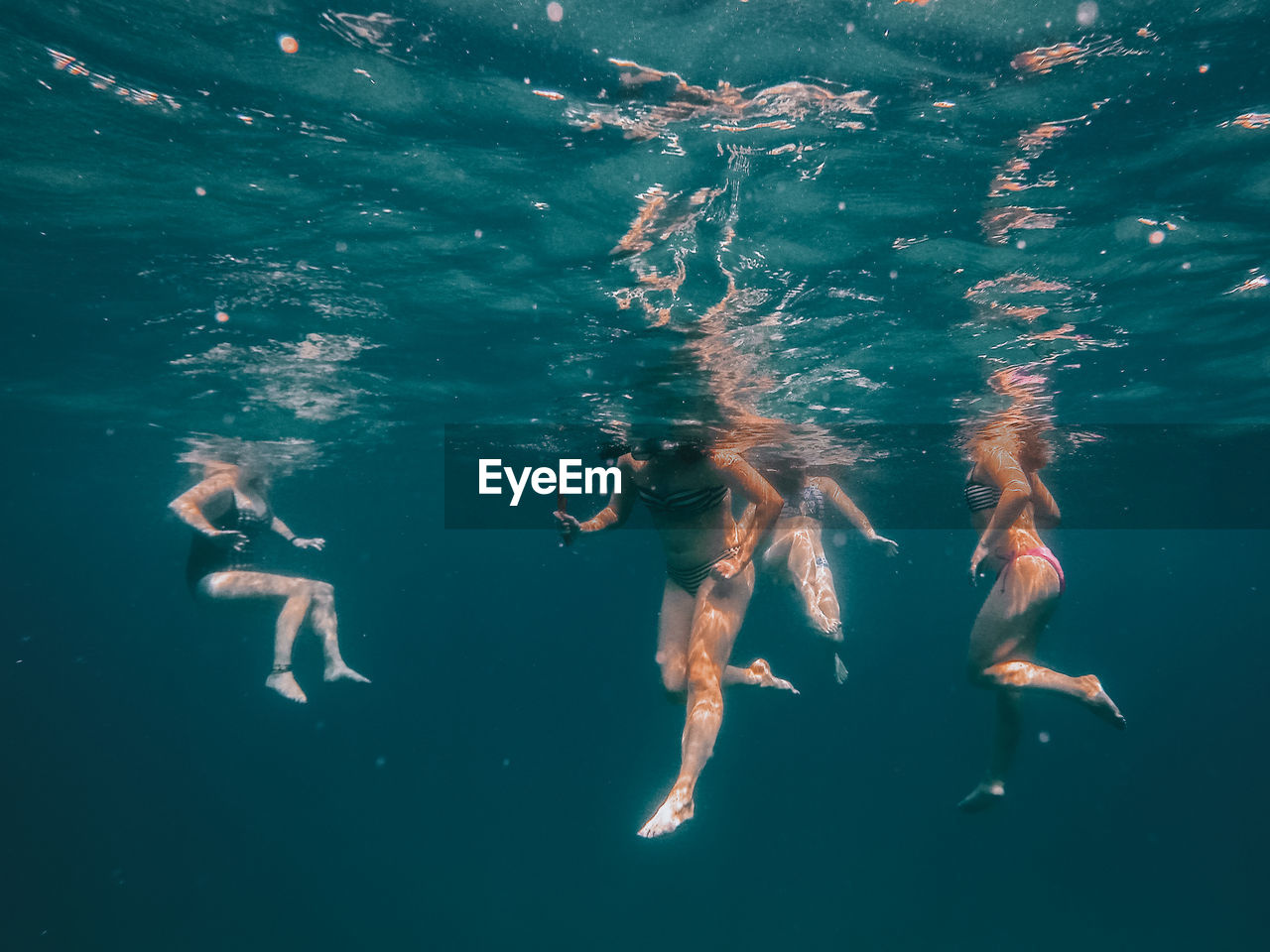 Low section of women swimming undersea
