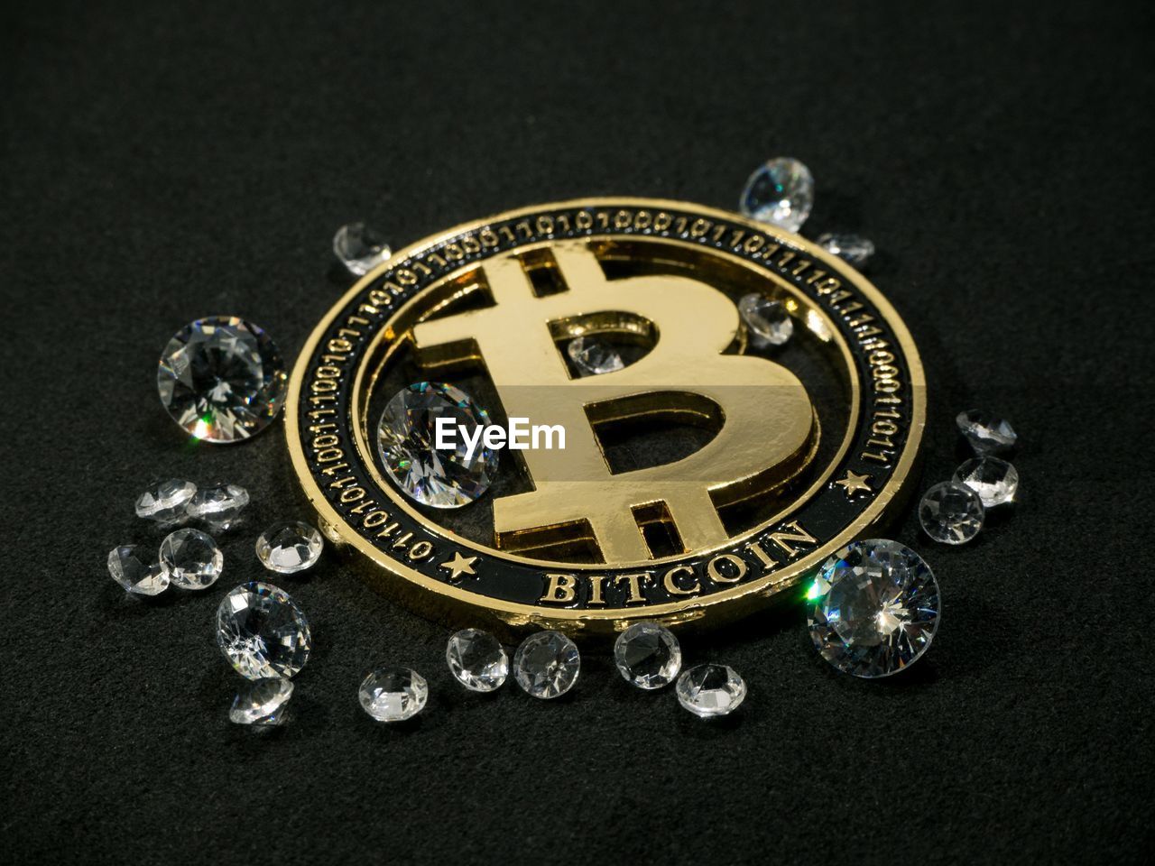 High angle view of bitcoin and diamonds on black background