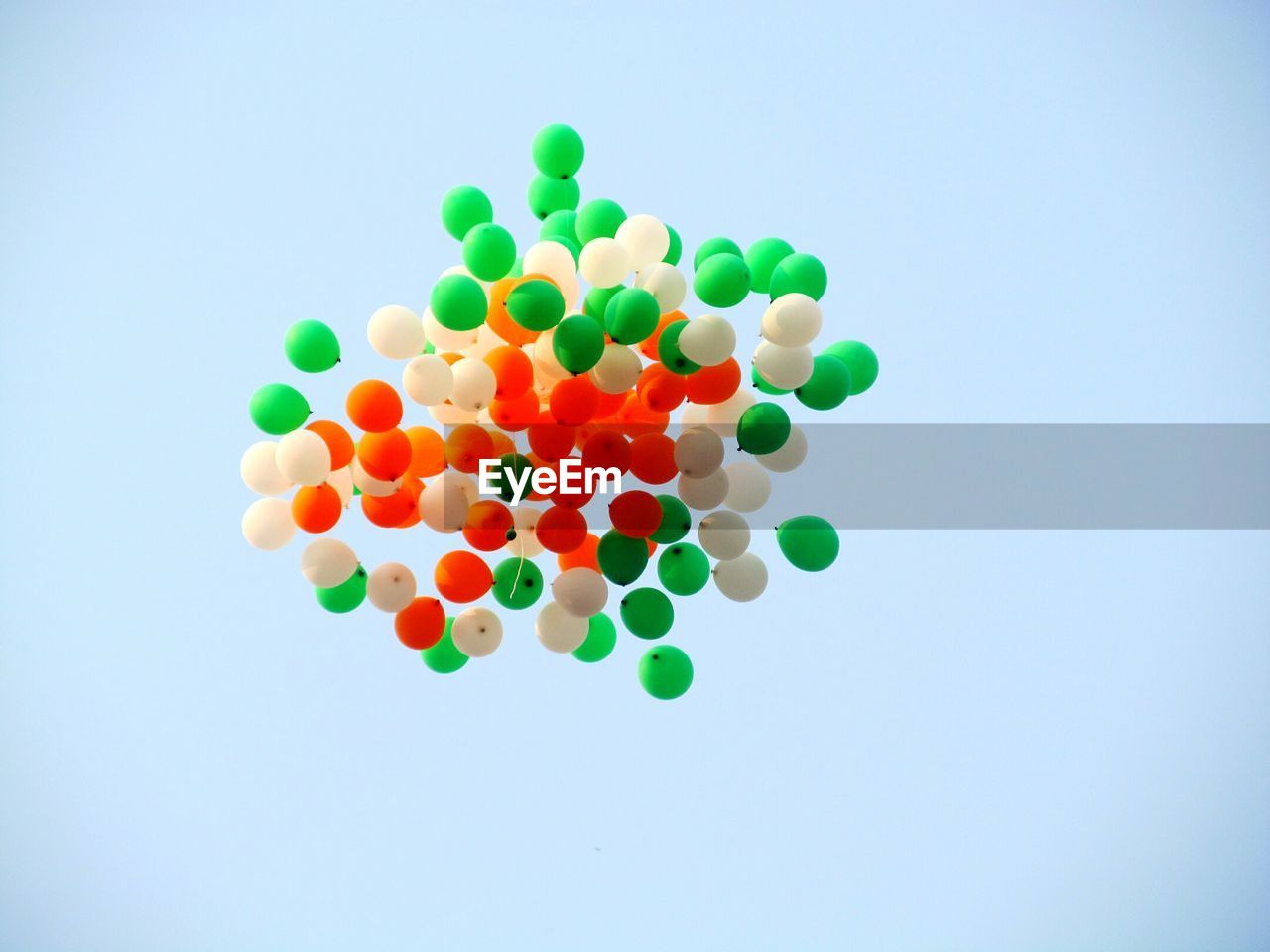 Balloons in colors of indian flag flying in clear sky