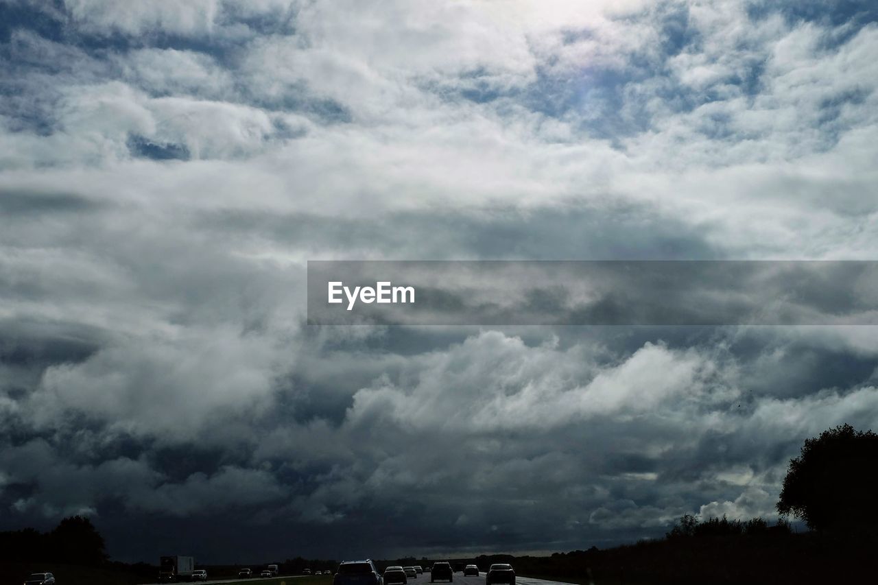 LOW ANGLE VIEW OF STORM CLOUDS OVER FIELD