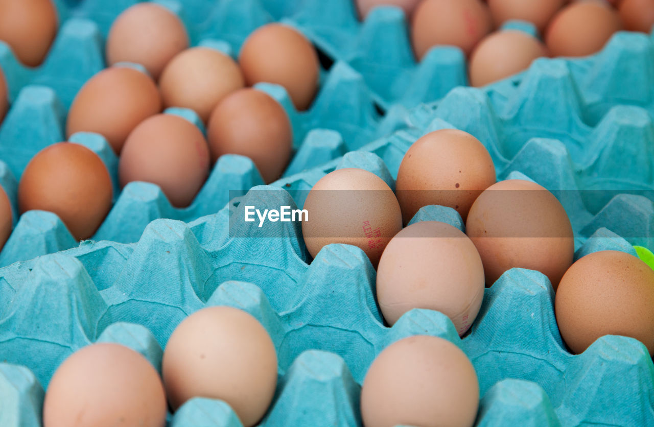 High angle view of brown eggs in carton for sale