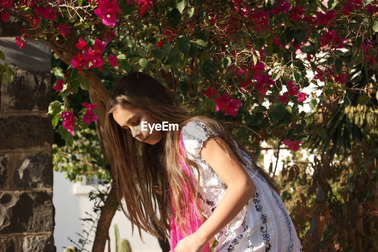 Close-up of girl standing against tree