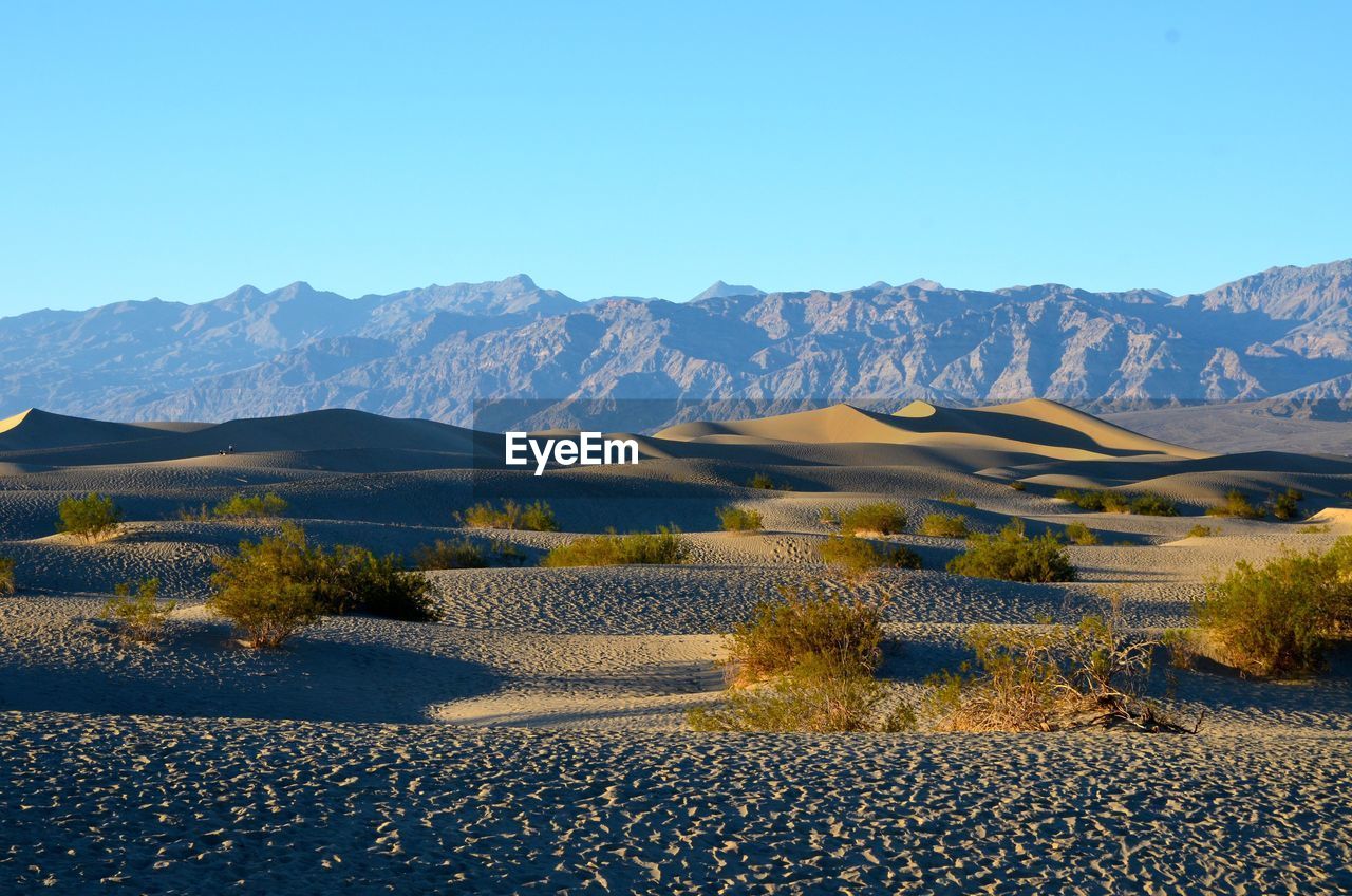 Scenic view of mountains against clear blue sky