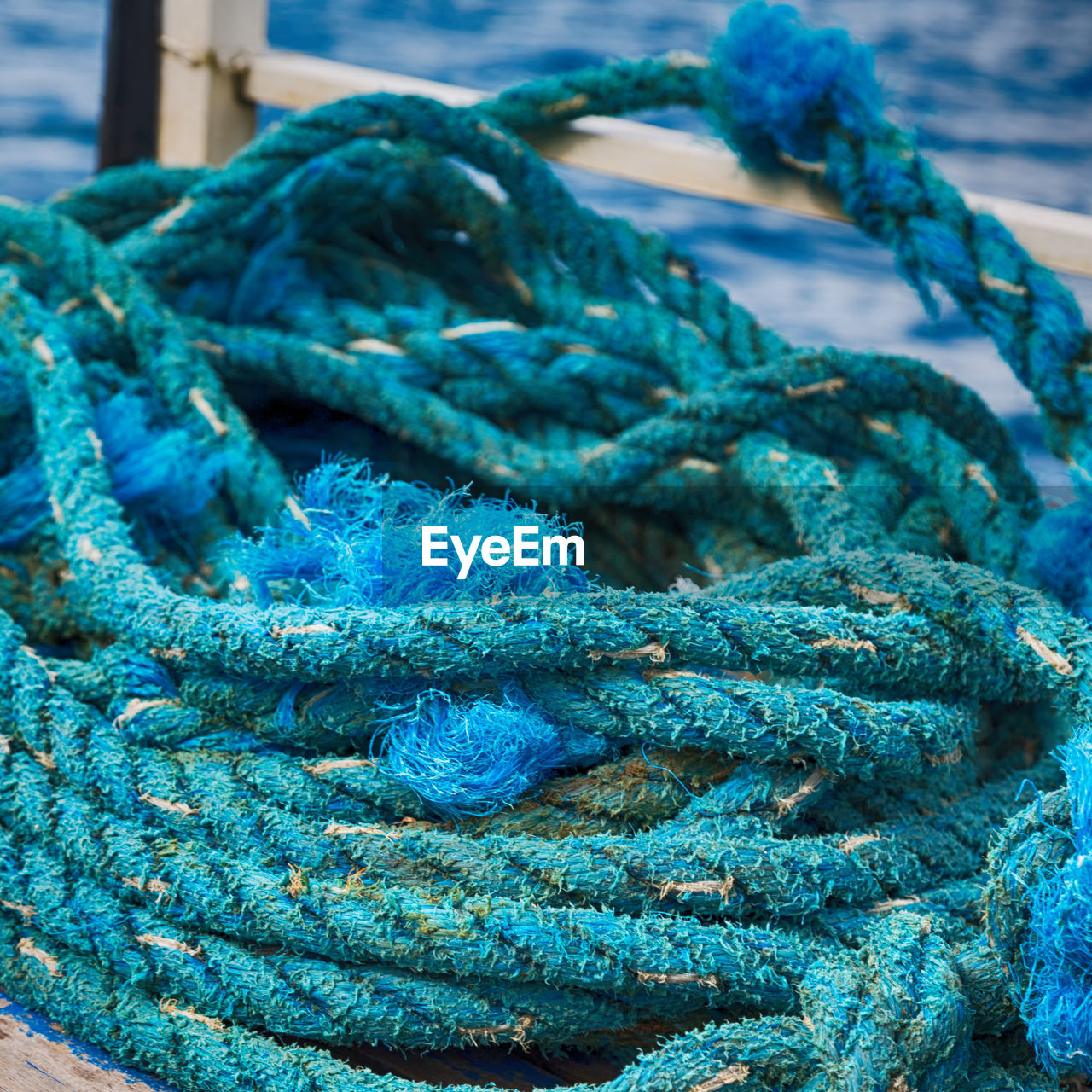 CLOSE-UP OF ROPE TIED UP ON BLUE FISHING