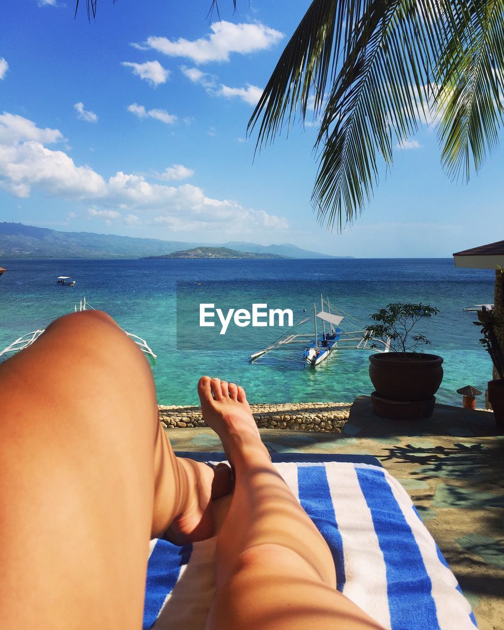 Low section of woman relaxing on beach