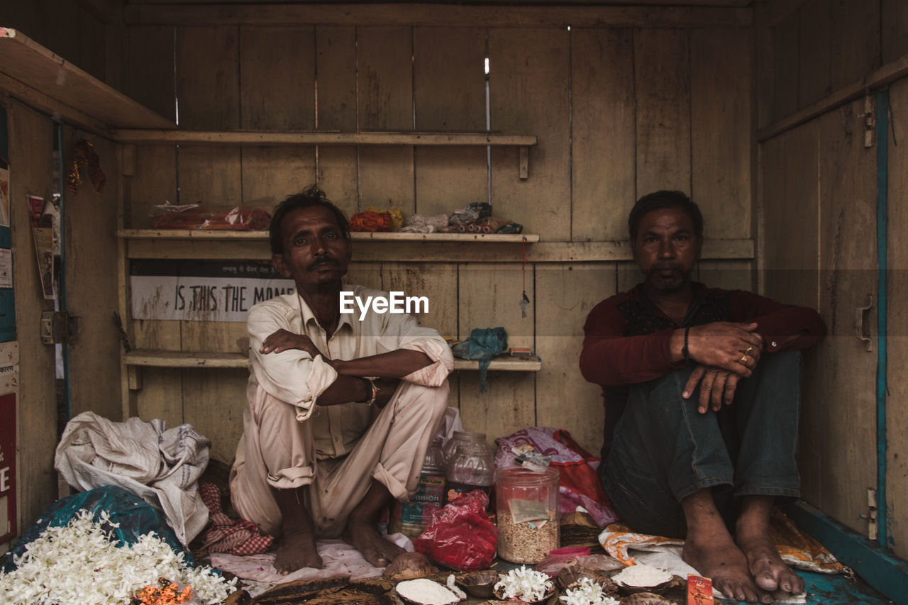 Portrait of young men sitting at their shop