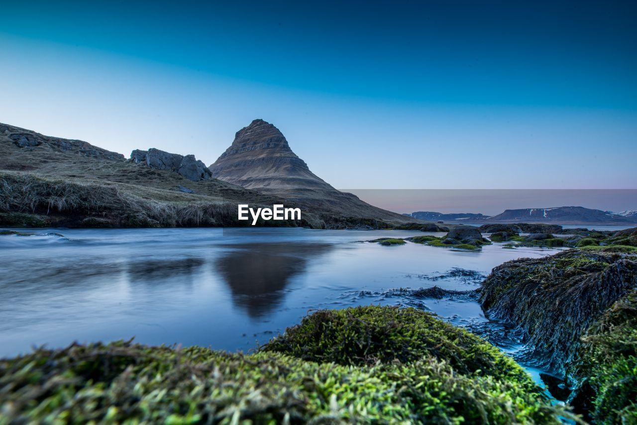 Scenic view of rocks and mountains against blue sky