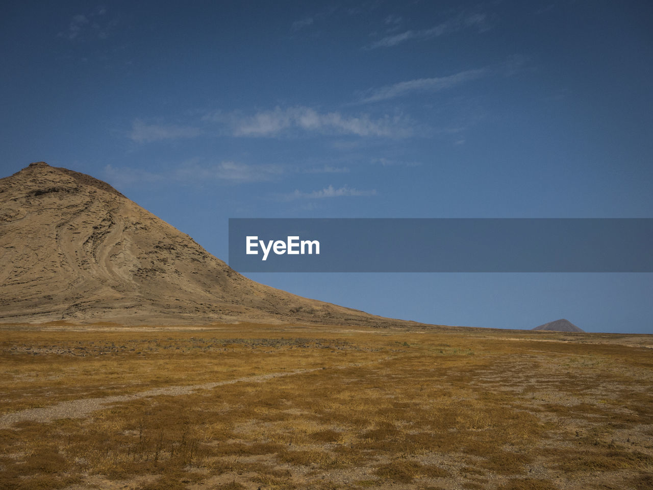 Scenic view of desert against blue sky