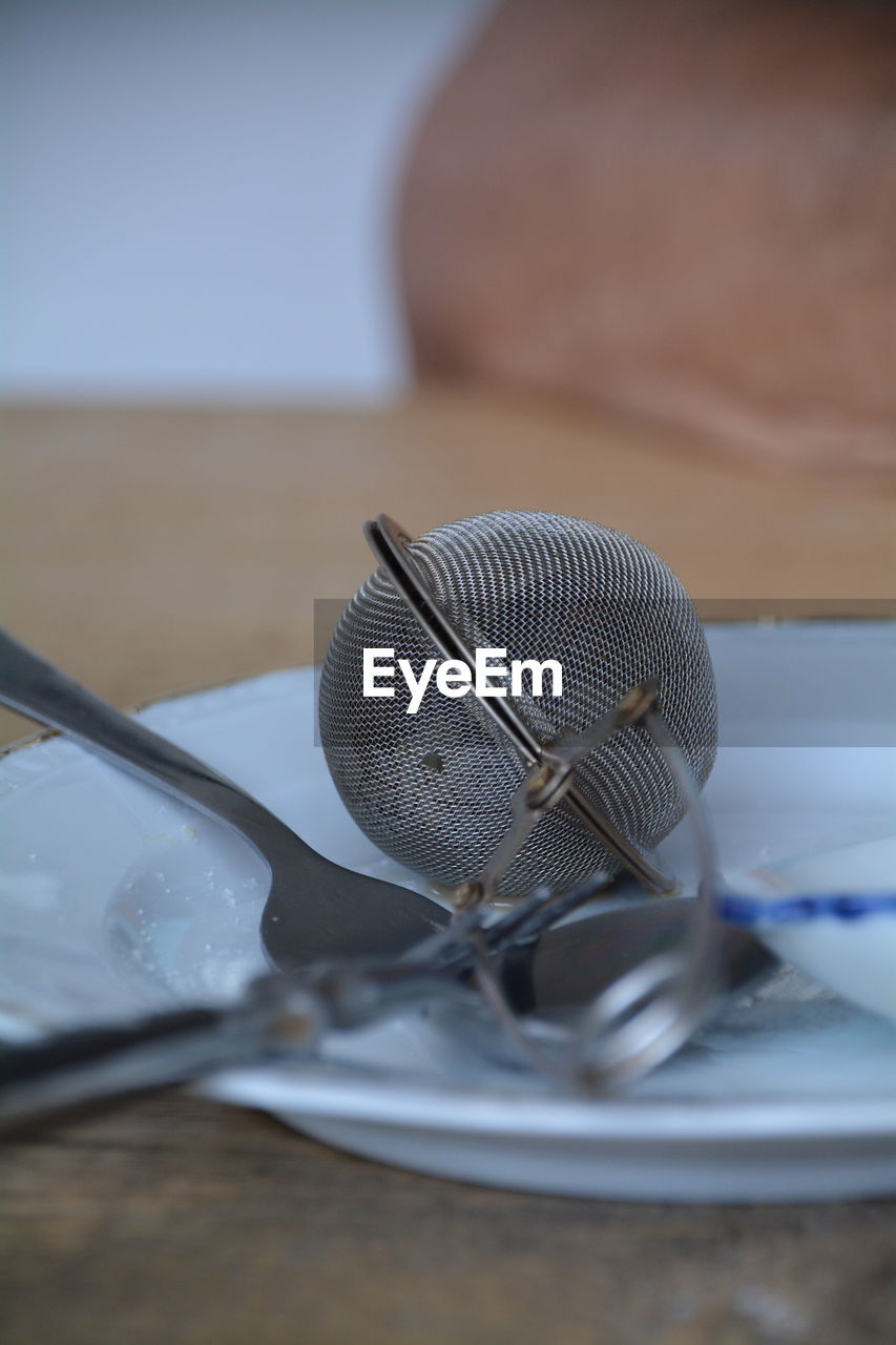 Close-up of empty plate and tea strainer