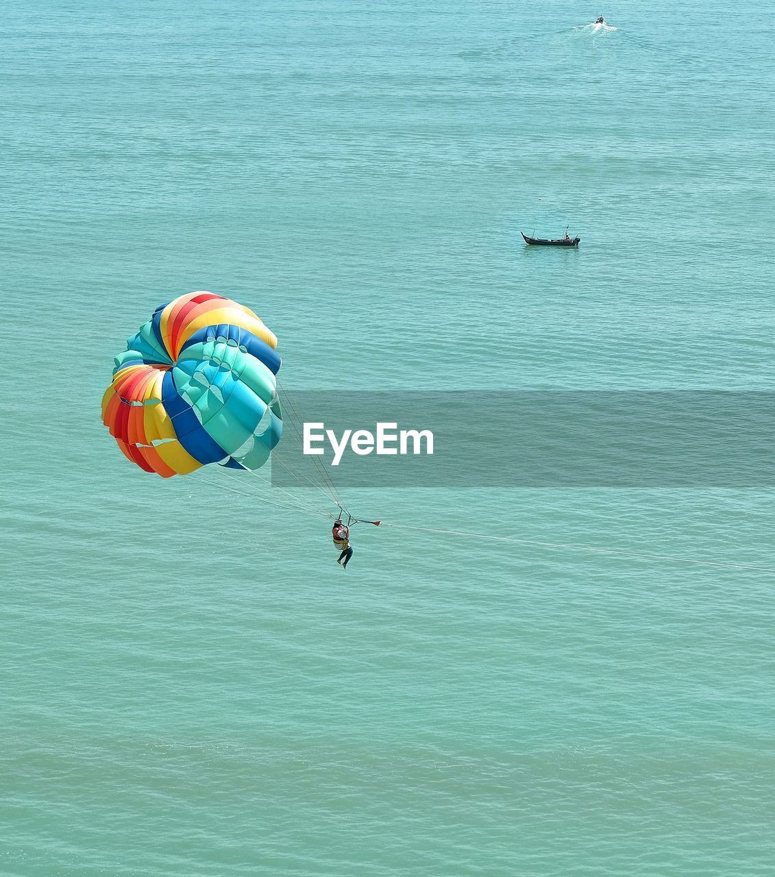 High angle view of parasailing over sea on sunny day