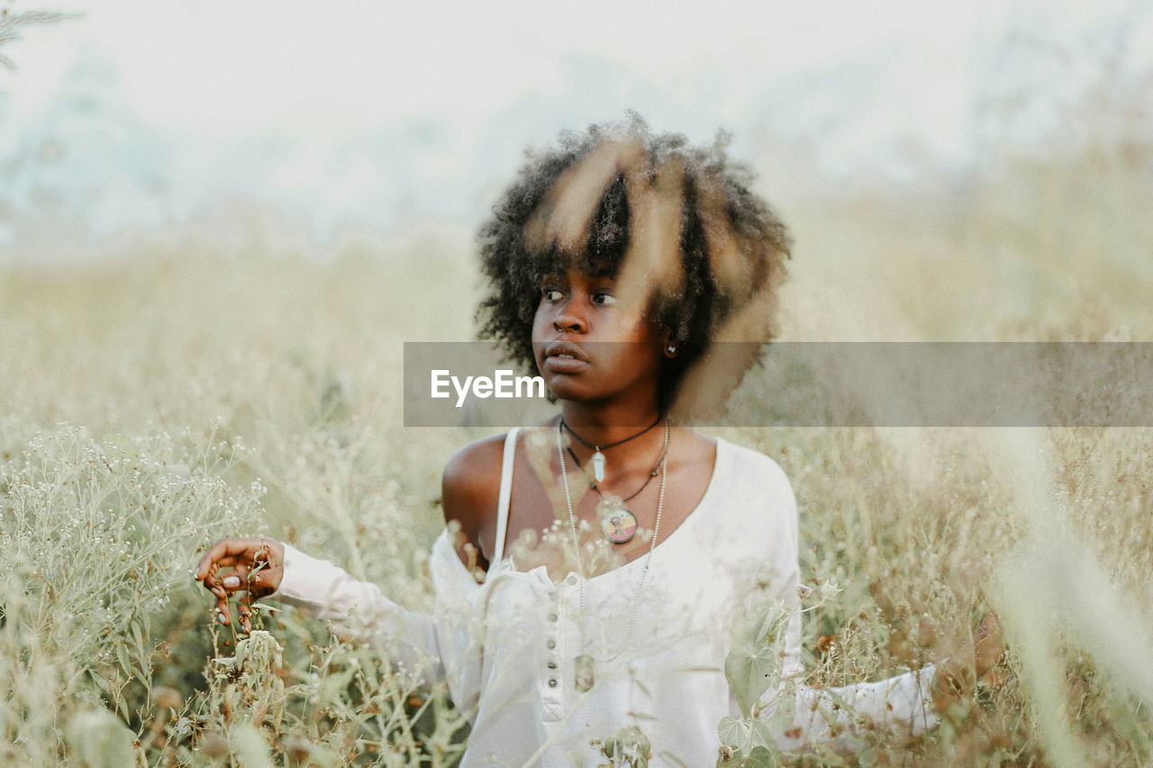 CLOSE-UP OF BEAUTIFUL WOMAN IN FIELD