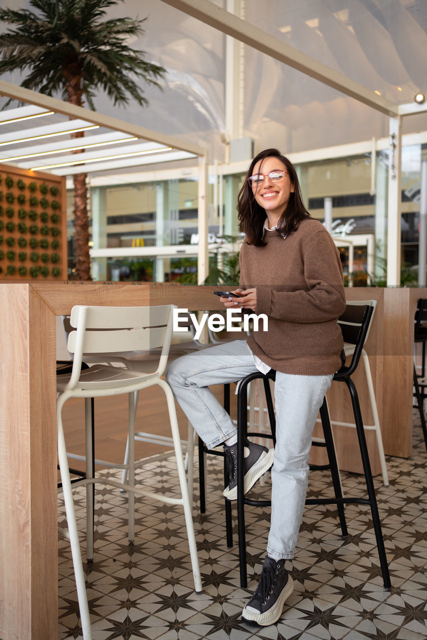 portrait of young woman sitting on table