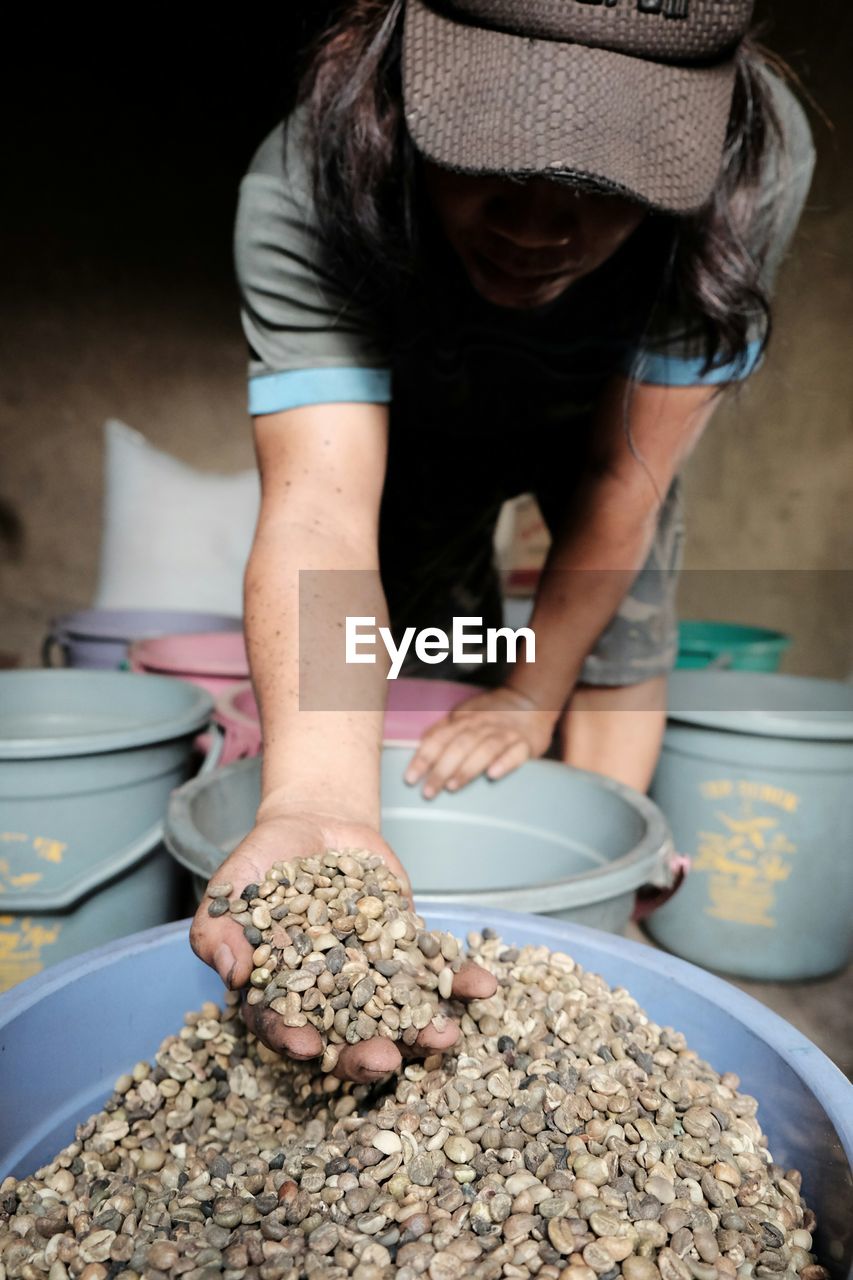 Young man with coffee beans in containers